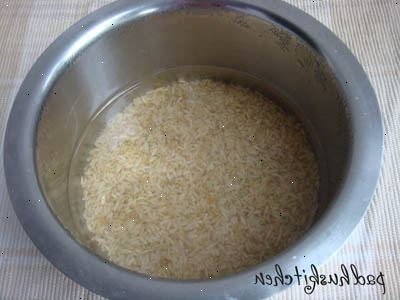 Sådan koger ris i en ris komfur. Måle ris med en kop og sætte det ind i din gryde.