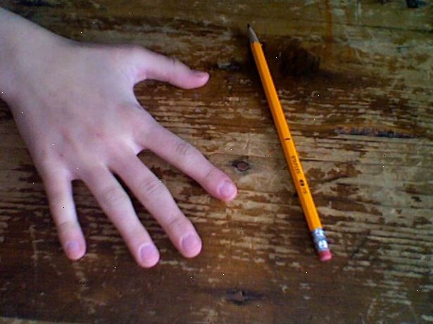 Hvordan til at spinde en blyant omkring din midterste finger. Hold blyanten den måde, du ville, når du skriver, undtagen placere den mellem midten og ringfinger, gribende den i centrum.