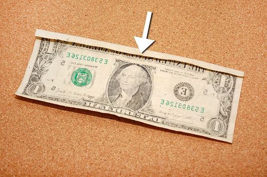 Sådan folde en dollarseddel til at lave en fingerring. Placer regningen på en flad overflade, opad.
