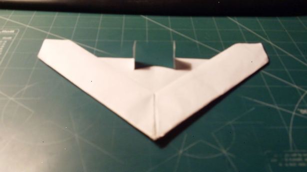 Hvordan man laver en delta vinge papirflyver. Krølle papiret at lokalisere centrum.