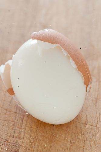 Sådan skrælle et æg. Forbered et hårdt kogt æg i salt vand og lad den afkøle.