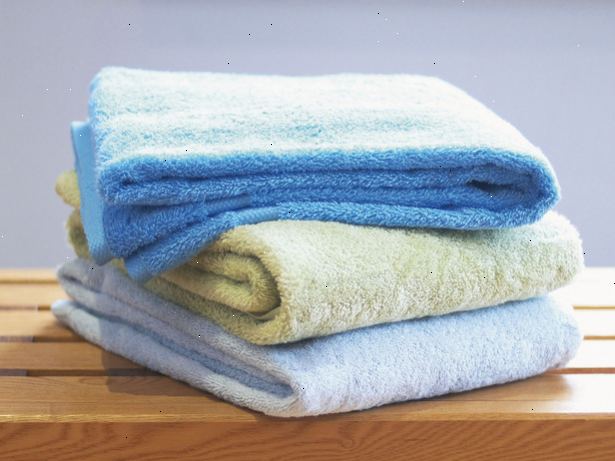 Sådan at folde håndklæder. Hold hver håndklæde ved hjørnerne på den samme side af den korteste kant.